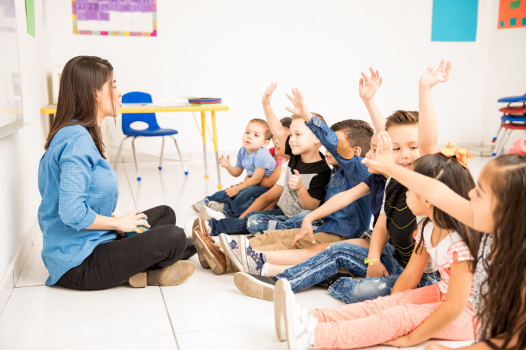 Preschool students raising their hands